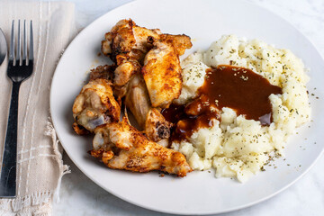 chicken  with mash potatoes top with gravy  and  seasoning