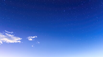 Naklejka premium Twinkling Starry Night Sky with White Clouds and Blue Gradient Background, Capturing Vast Universe and Starlight, High Definition Long Exposure Photography Using Wide-Angle Lens, Low Angle Night View 