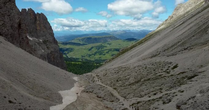 Sassolungo mountain peak trail with a view on Compatsch meadows at the beginning of summer, Dolomites Alps, Italy