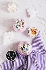 Berry milkshake with marshmallows, chocolate and sprinkles in glasses top and  vertical view