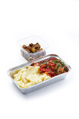 a white background disposable plastic and foil tableware airplane food snack mashed potatoes with chicken fillet with stewed vegetables healthy nutrition