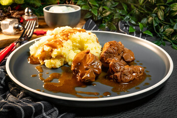 Stewed turkey meat served with sauce and mashed potatoes.