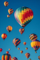 Obraz premium Colorful hot air balloons float above a vibrant crowd during a festival at dawn