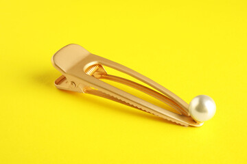 Beautiful bijouterie. Stylish hair clip on yellow background