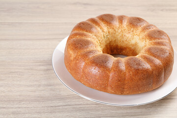 Freshly baked sponge cake on wooden table, closeup