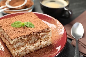 Delicious tiramisu with mint on dark table, closeup