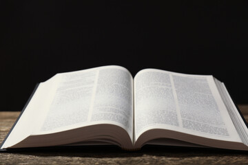Open Holy Bible in English language on wooden table, closeup. Space for text