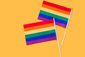 LGBT rainbow flag flat lay on yellow color background. gay marriage, human rights, june parade, lgbtq proud history month concept, coming out day. top view, place for text or logo