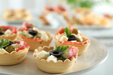 Many tasty canapes on white table, closeup