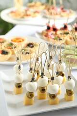 Many different tasty canapes on white table, closeup