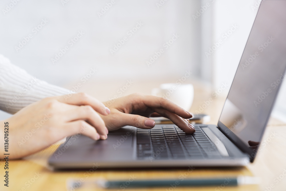 Poster a close-up view of female hands typing on a state-of-the-art laptop keyboard, with a blurry office s