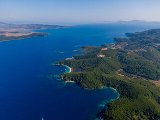 Aerial view of a breathtaking coastline with lush greenery and azure waters.