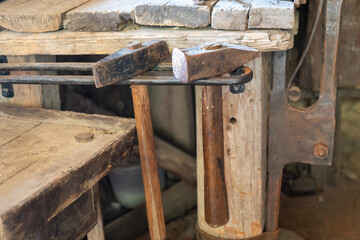 Close-up of blacksmith hammers on a wooden workbench in an old workshop