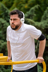 Hombre entrenando duro haciendo dominadas de tríceps en el parque