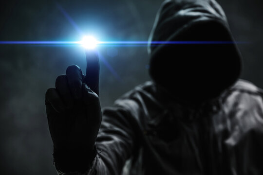 Computer hacker in hoodie using virtual screen. Database hacking, computer virus malware and cybersecurity concept.