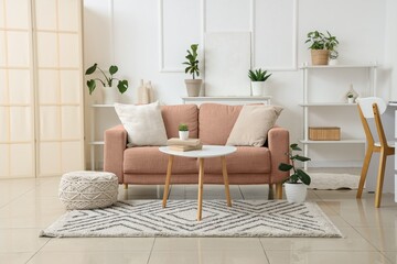 Interior of light living room with sofa, table and plants