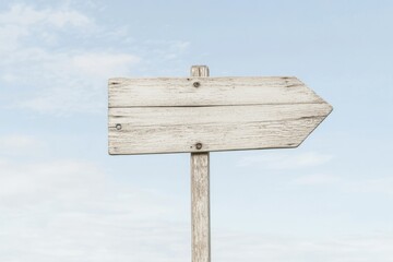 Fototapeta premium Sun-bleached wooden signage with weathered texture points toward an unknown destination under a bright sky