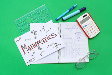 Paper sheet with word MATHEMATICS and school stationery on green background