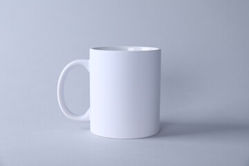 One blank white mug on light background. Mockup for design