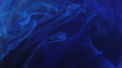 Water dye. Fluid blowing. Defocused blue splash paint ink mist cloud magical smoke moving on abstract art background.