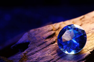 Beautiful shiny light blue gemstone on stone against dark background, closeup