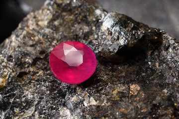 One beautiful shiny pink gemstone on stone