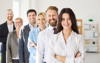 Smiling supportive diverse businesspeople team standing, confident excited male, female employees happy with job promotion or hr success, colleagues enjoy work achievement, welcoming new member 