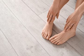 Young woman with flat feet on floor at home, closeup