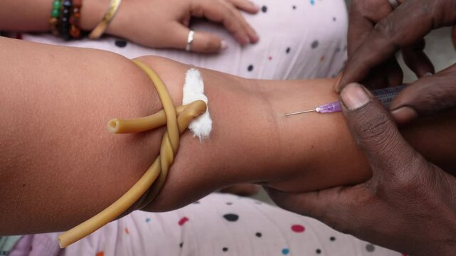 Pathologist is collecting blood from the vein in closeup