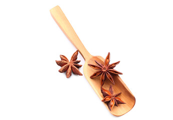 Wooden scoop with star anise on white background