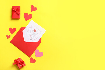 Envelope with gift card, boxes and paper hearts on yellow background. Valentine's day celebration