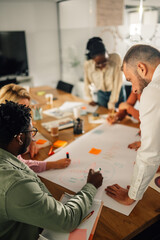 Diverse business team drawing mind map during brainstorming session