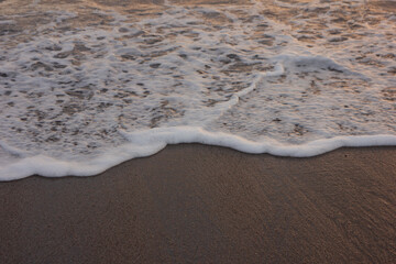 The wave breaks on the shore. White sea foam silhouette