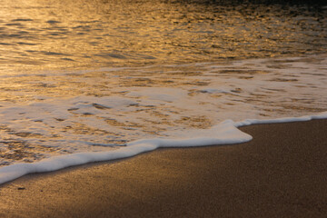 The wave breaks on the shore. White sea foam silhouette