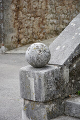 A worn stone sphere rests on a stone base at the bottom of stone steps