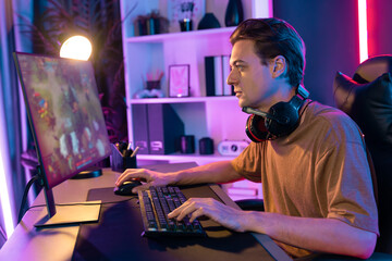 Host channel concentrated smart gaming streamer playing the fighting Moba on computer screen with muptiplayers or single at battle arena . Esport live streaming at neon digital light room. Pecuniary.