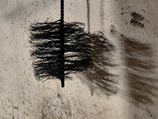 chimney brush wire with his shadow on the wall