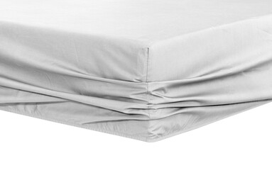 White fitted sheet over mattress with elastic band, White fitted sheet elasticized on a white background Bed corner, closeup