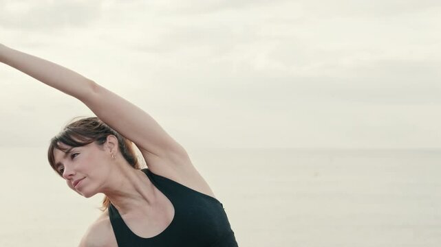 Young atractive girl warming up with blured background, performs side bends