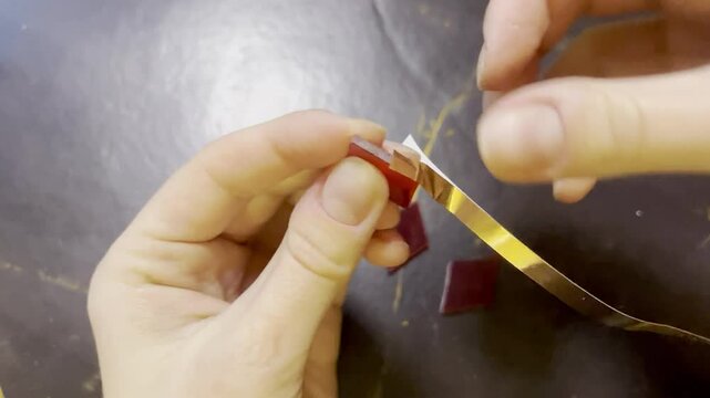 winding stained glass element glass rhombus metal copper tape for soldering blank for tiffany lamp handmade top view female hands evening workshop