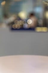 Close-up view of empty round wooden table in modern cafe. Focus on table surface. Blurred espresso coffee machine in the background. Copy space for your text or decoration. Food business theme.