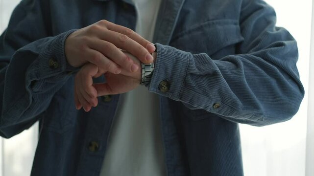 A man in a blue shirt checks the time on his wristwatch.
A man looks at the time on his watch.
Time on wristwatch.
A business man has a watch on his hand.
Man is in a hurry and looks at his watch
