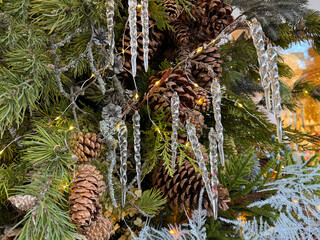 Christmas tree is decorated with pine cones and icicles