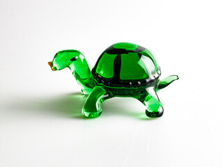 A figurine of a green turtle, specially made of glass on a white background.