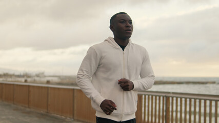 Athlete running along the seaside promenade, cardio workout