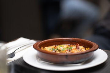 Spicy grilled fresh scampi or lobster with garlic and herbs served in a brown ceramic bowl. Perfect for food photography, seafood dishes, gourmet meals, or Mediterranean cuisine visuals.