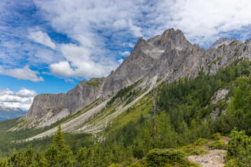 Obraz premium Dolomites sunny weather in summer mountains. Green valley and beautiful mountain rocky peaks in the Alps. Alpine scenic landscape in South Tyrol region in Italy