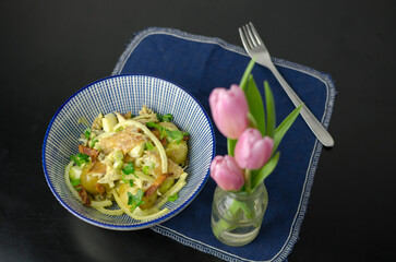 Warm New Potato & Smoked Mackerel Salad in a bowl, blue napkin on a black background