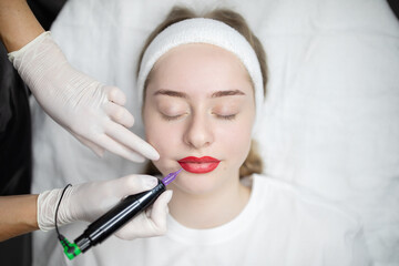 Two woman are engaged in a beauty procedure in a salon, applying long-lasting permanent makeup to...