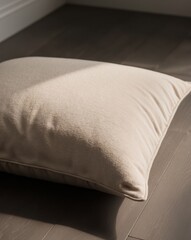 Fototapeta premium A beige pillow sitting on top of a wooden floor